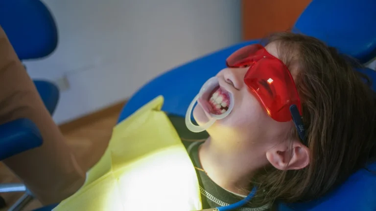 Paciente con protección ocular y separador labial durante un tratamiento estético en OdontoBa